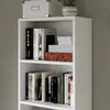 A close-up shot of a white bookshelf filled with books and decorative boxes. Anteprima dell’immagine prodotto