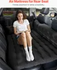 A woman is sitting on an inflatable mattress in the back of a car, reading a book. Produktbild-Vorschau