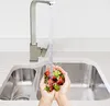 Hands washing strawberries under a kitchen faucet. Produktbild-Vorschau