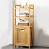 A tall, narrow bamboo shelf unit with a cabinet at the bottom, placed in a room with a white wall and a light gray floor. Produktbild-Vorschau