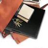 A close-up shot of a brown leather bag with a tablet, wallet, and keys inside. Anteprima dell’immagine prodotto