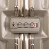 A close-up of a TSA-approved combination lock on a gold suitcase. Podgląd zdjęcia produktu