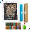 A diamond painting kit laid out on a white background, featuring a canvas with a lion's face, bags of colored diamonds, a pen, and a box. Produktbild-Vorschau