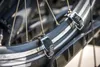 A close-up view of a bicycle wheel with straps attached to the rim. Produktbild-Vorschau