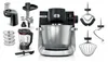 A collection of kitchen appliance attachments and a food processor base are displayed against a white background. Náhled obrázku produktu