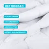A close-up of a white comforter with text overlays indicating different uses. Produktbild-Vorschau