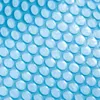 A close-up of a blue bubble wrap pool cover. Voir les images du produit