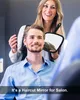 A hairdresser is holding a mirror for a man to see his haircut. Produktbild-Vorschau