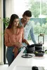 A couple is cooking together in a modern kitchen. Voir les images du produit