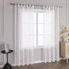 A window with white sheer curtains featuring a subtle floral pattern, set in a room with a small side table and a cabinet. Produktbild-Vorschau