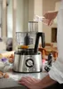 A person is pouring liquid into a food processor on a kitchen counter. Náhľad obrázku produktu