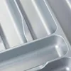 A close-up view of a gray plastic cutlery organizer with multiple compartments. Produktbild-Vorschau