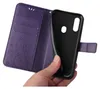A hand holding a purple flip phone case with floral embossing. Produktbild-Vorschau