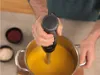 A person is using an immersion blender to blend soup in a pot. Náhled obrázku produktu
