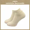 A pair of beige ankle socks on a white background with text overlay. Produktbild-Vorschau