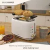 A white toaster with bread warming on top, next to a glass of orange juice and a mug of coffee. Produktbild-Vorschau