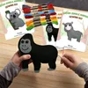 Hands holding a felt gorilla sewing kit, with other sewing kits and threads in the background. Produktbild-Vorschau