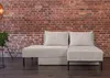A modern living room with a brick wall and a beige sofa. Produktbild-Vorschau