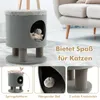 A cat tree with a cat inside, shown in a living room setting with a sofa in the background. The image is divided into sections highlighting different features. Náhľad obrázku produktu