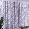 A curtain of white LED lights hanging in front of sheer white curtains. Náhled obrázku produktu