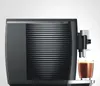 A close-up shot of a black espresso machine with a glass of coffee. Podgląd zdjęcia produktu