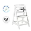 A white wooden high chair with safety straps, shown against a white background. Two circular certification logos are visible on the left side of the image. Náhled obrázku produktu