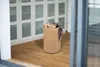 A laundry basket filled with clothes sits on a wooden floor in front of a white wardrobe. Náhled obrázku produktu