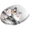 A toilet seat with a decorative print of stones, flowers, and a butterfly. Náhľad obrázku produktu