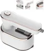 A white and gold portable steam iron is shown from a low angle. Produktbild-Vorschau