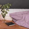 A fuchsia fitted sheet is draped over a mattress, with a vase of flowers and a notebook on a wooden surface in the foreground. Anteprima dell’immagine prodotto