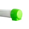 A close-up view of the end of a white tube with a bright green cap on it. Produktbild-Vorschau