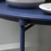 A close-up view of the leg and edge of a blue table. Produktbild-Vorschau
