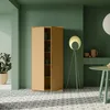 A modern room with a beige cabinet, a floor lamp, and a round table, all set against green walls and a patterned floor. Produktbild-Vorschau