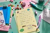 A child's desk with stationery, a letter, and craft supplies. Anteprima dell’immagine prodotto