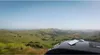 A view of rolling green hills from the roof of a vehicle, with a Starlink Mini device on the roof. Produktbild-Vorschau