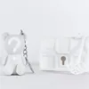 A white bear-shaped keychain and a white treasure chest with a key are displayed against a white background. Podgląd zdjęcia produktu