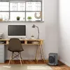 A compact heater is placed on the floor next to a desk in a home office setting. Voir les images du produit