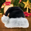 A black and white Santa hat is placed on a wooden surface in front of a Christmas tree with decorations. Produktbild-Vorschau