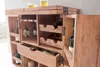 A wooden bar cabinet with wine bottles and glasses inside. Produktbild-Vorschau