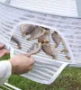 A person is shown taking dried fish out of a mesh drying net. Náhľad obrázku produktu