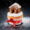 A festive cupcake decorated with a gingerbread house and dusted with powdered sugar. Produktbild-Vorschau