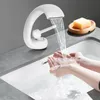 A person is washing their hands under a modern white faucet in a bathroom sink. Podgląd zdjęcia produktu