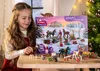 A young girl is holding an advent calendar with horse-themed toys. Produktbild-Vorschau