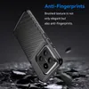 A black phone case with a textured surface is shown at an angle, resting on a surface of broken rocks and debris. The background is dark. Produktbild-Vorschau