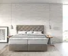 A bedroom scene with a bed as the main focus, set against a white brick wall. Produktbild-Vorschau
