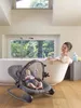 A woman is taking a bath while a baby is in a bouncer next to the tub. Produktbild-Vorschau