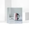 A pink Cuisinart jug kettle is displayed on its packaging, which features a lifestyle image of the kettle. Voir les images du produit