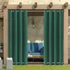 Outdoor patio area with green curtains, blue sofa, and coffee table. Produktbild-Vorschau
