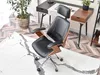 A modern office chair with a walnut and black finish is placed on a marble-patterned rug in front of a desk. Anteprima dell’immagine prodotto