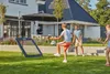 Children playing soccer with a rebounder in a backyard. Podgląd zdjęcia produktu